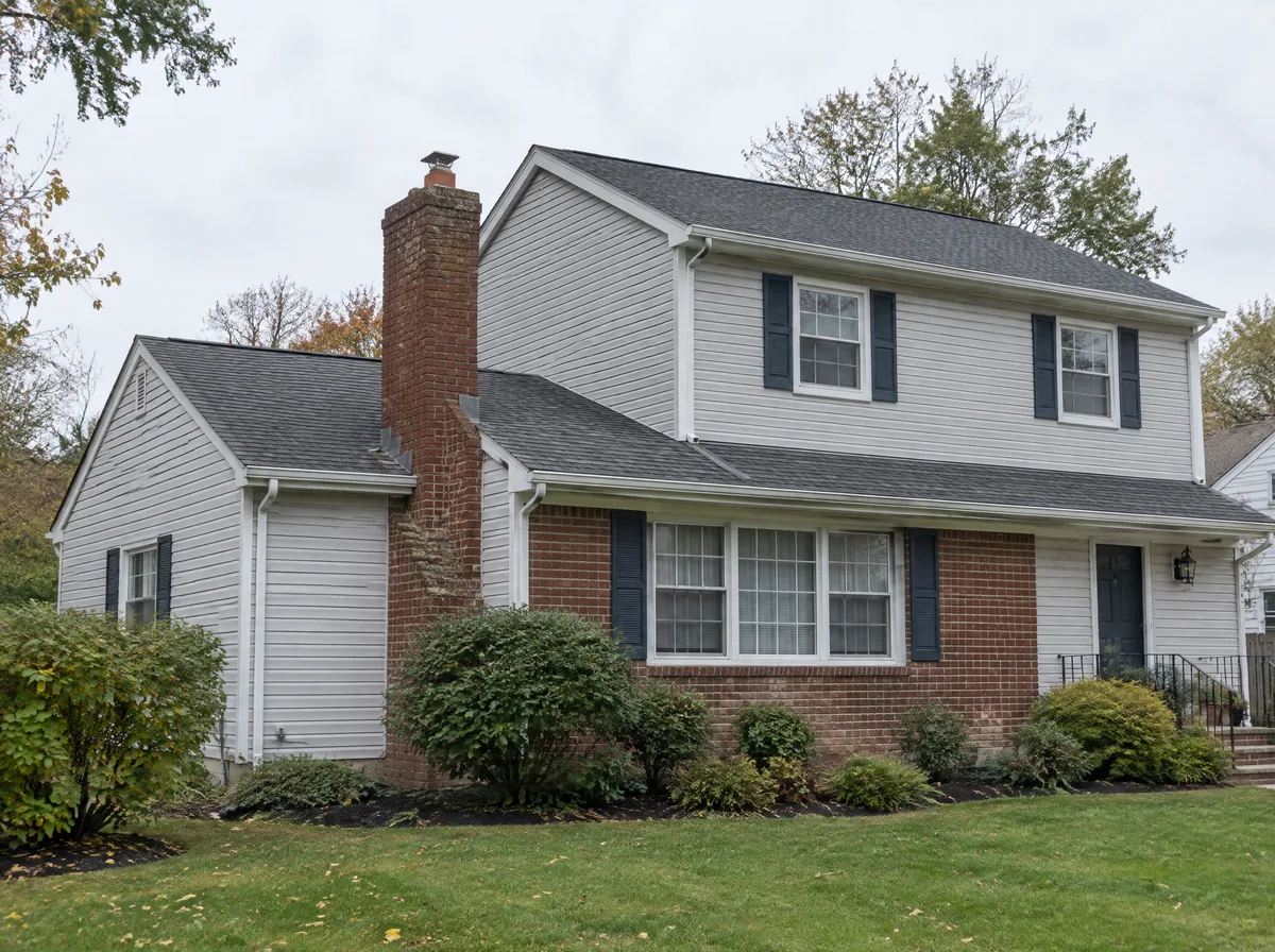Brick chimney beside a newer second-story addition on a suburban house